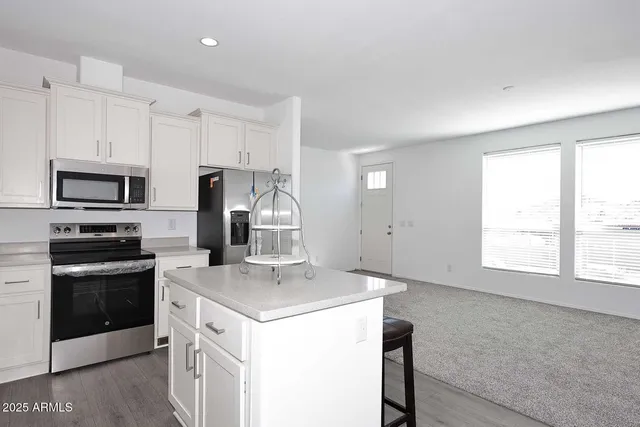 a kitchen with a sink a stove a microwave and a refrigerator