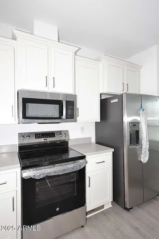 a kitchen with white cabinets and stainless steel appliances