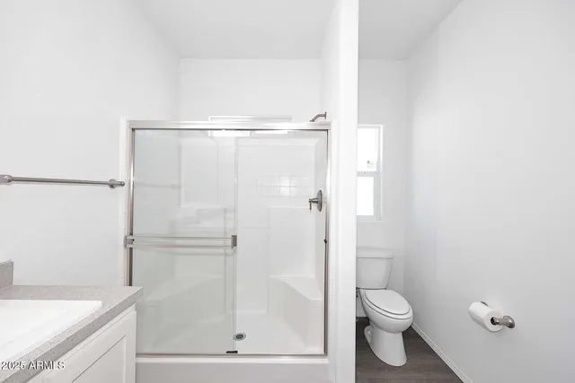 a bathroom with a shower a toilet and a sink