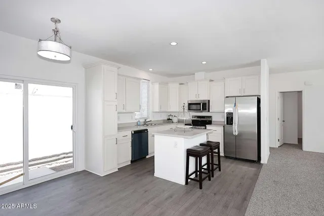 a kitchen with a refrigerator a sink dishwasher a stove and a oven with wooden floor