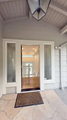 a view of an empty room with a fireplace and a window