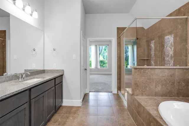 a bathroom with a granite countertop sink a toilet and shower