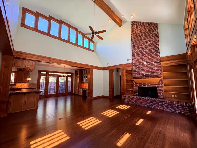 a view of a livingroom with wooden floor and a fireplace