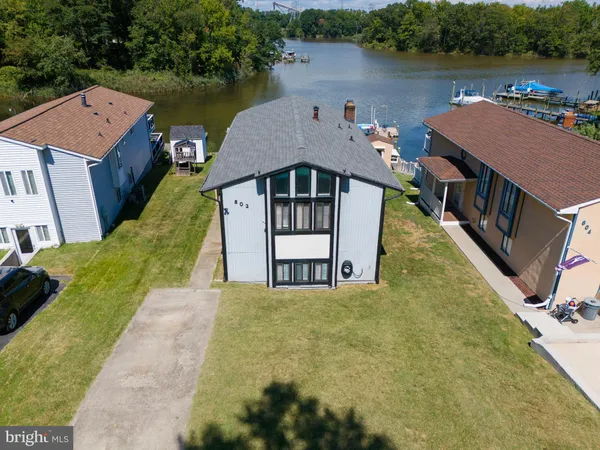 an aerial view of residential houses with outdoor space and lake view