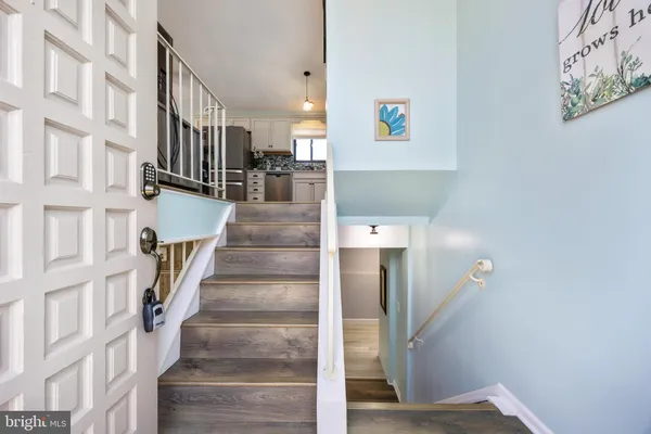 a kitchen with stainless steel appliances wooden floor and a refrigerator