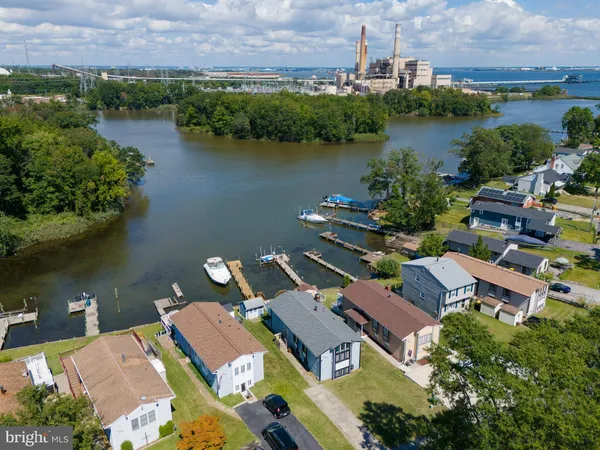 an aerial view of residential houses with outdoor space and lake view
