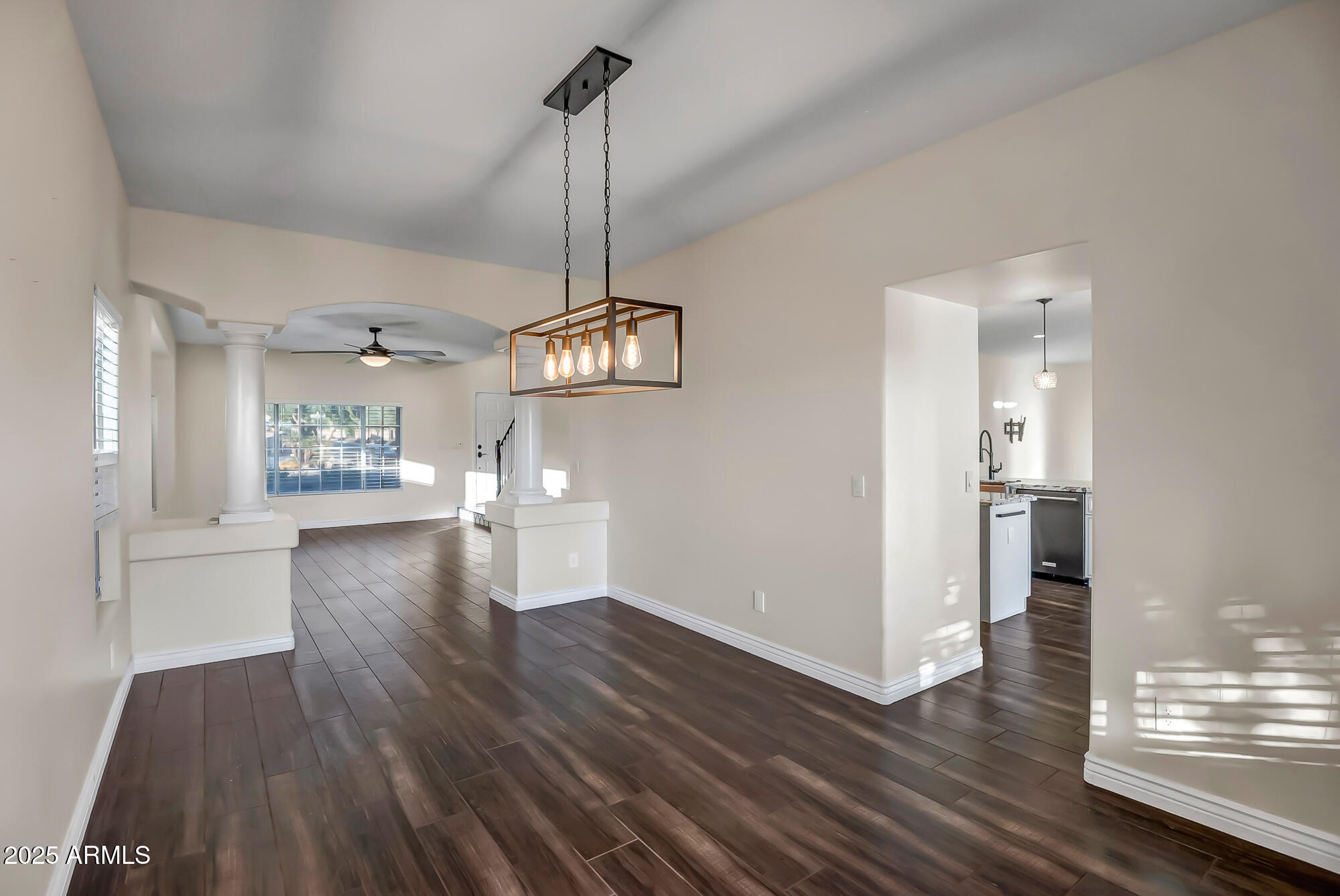 9569 West Redbird Road Peoria, AZ 85383 - Photo 13 of 36 a view of a big room with wooden floor a kitchen and windows
