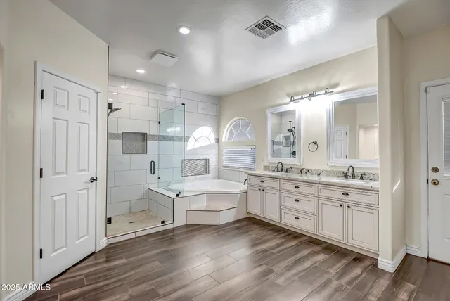 a large bathroom with a large mirror vanity and shower