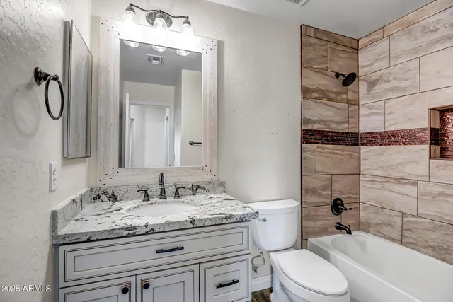 a bathroom with a granite countertop sink toilet and shower