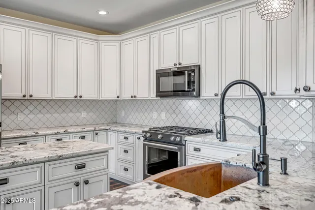 a kitchen with appliances a sink and cabinets