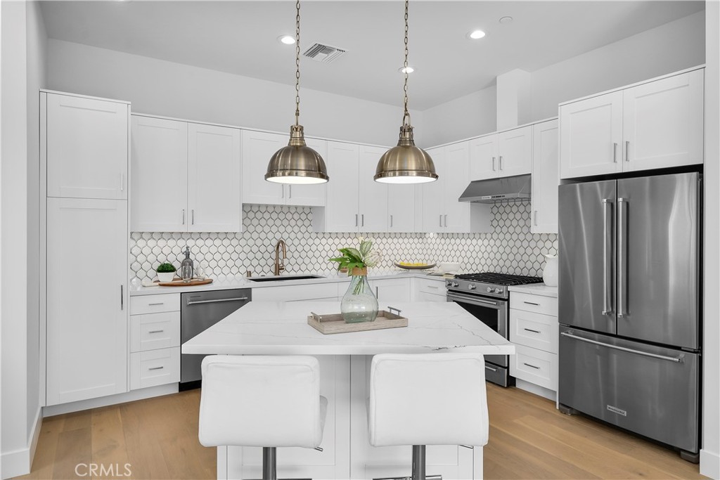 2317 Vanderbilt Lane, Unit A Redondo Beach, CA 90278 - Photo 4 of 39 a kitchen with stainless steel appliances a stove a sink a refrigerator a center island a stove and a wooden floors