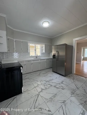 a kitchen with granite countertop a refrigerator and a stove top oven