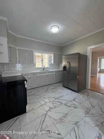 a kitchen with granite countertop a refrigerator and a stove top oven