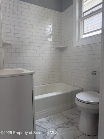 a bathroom with a toilet and bathtub