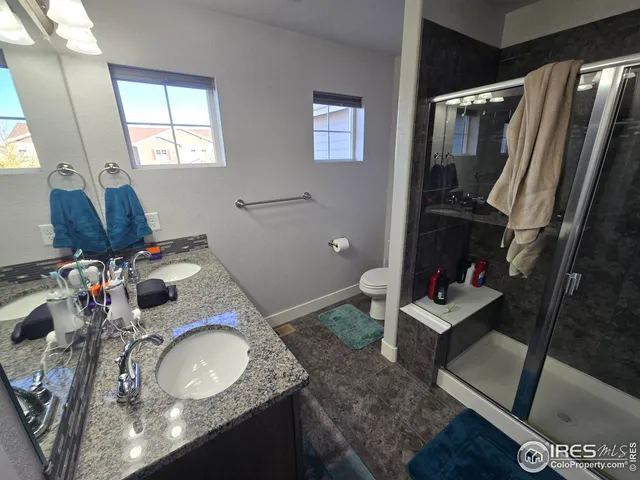 a bathroom with a granite countertop sink toilet and mirror