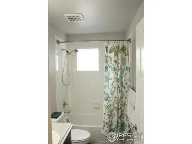 a bathroom with a toilet and shower curtain