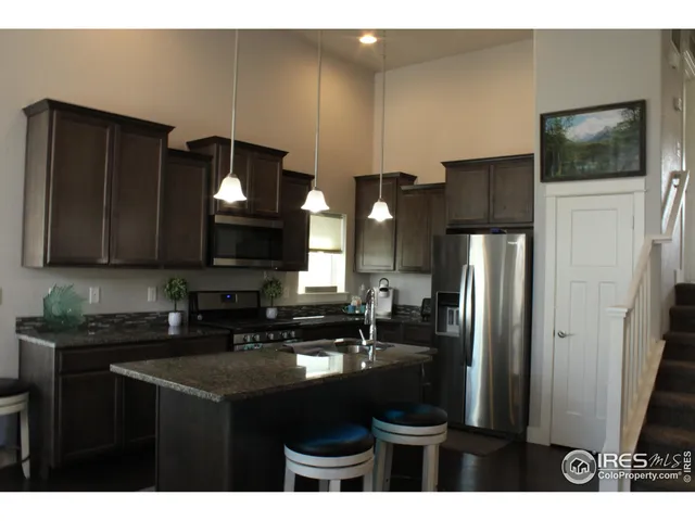 a kitchen with a sink a refrigerator and cabinets