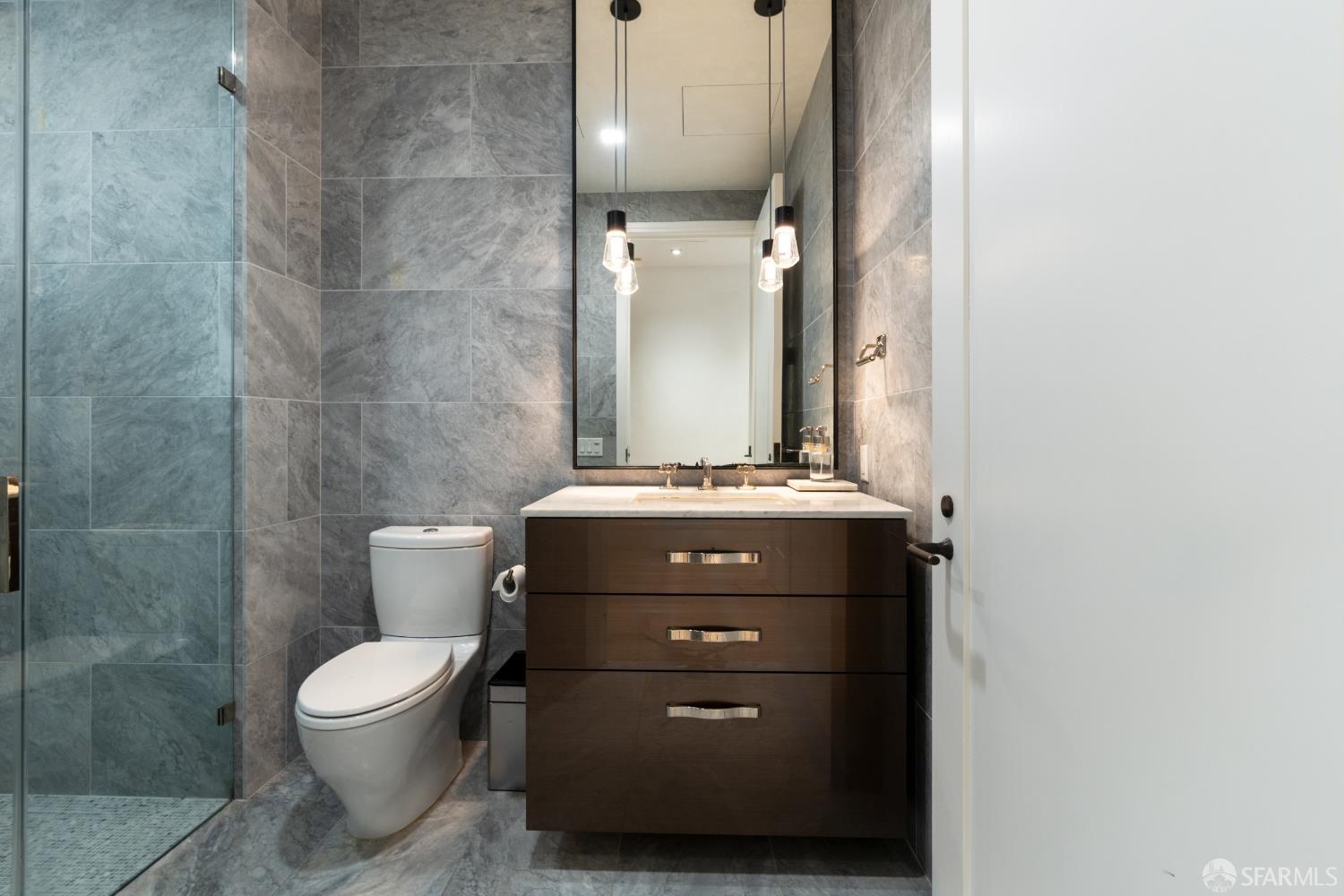 288 Pacific Avenue, Unit 2F San Francisco, CA 94111 - Photo 17 of 34 a bathroom with a toilet a sink and mirror