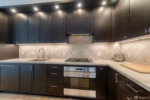 a kitchen with granite countertop wood cabinets and stainless steel appliances
