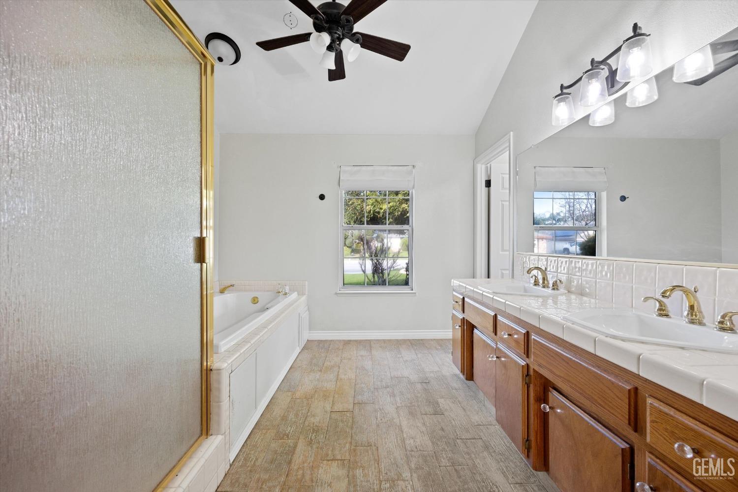 Undisclosed Address Bakersfield, CA 93308 - Photo 26 of 48 a spacious bathroom with a double vanity sink a mirror and a bathtub