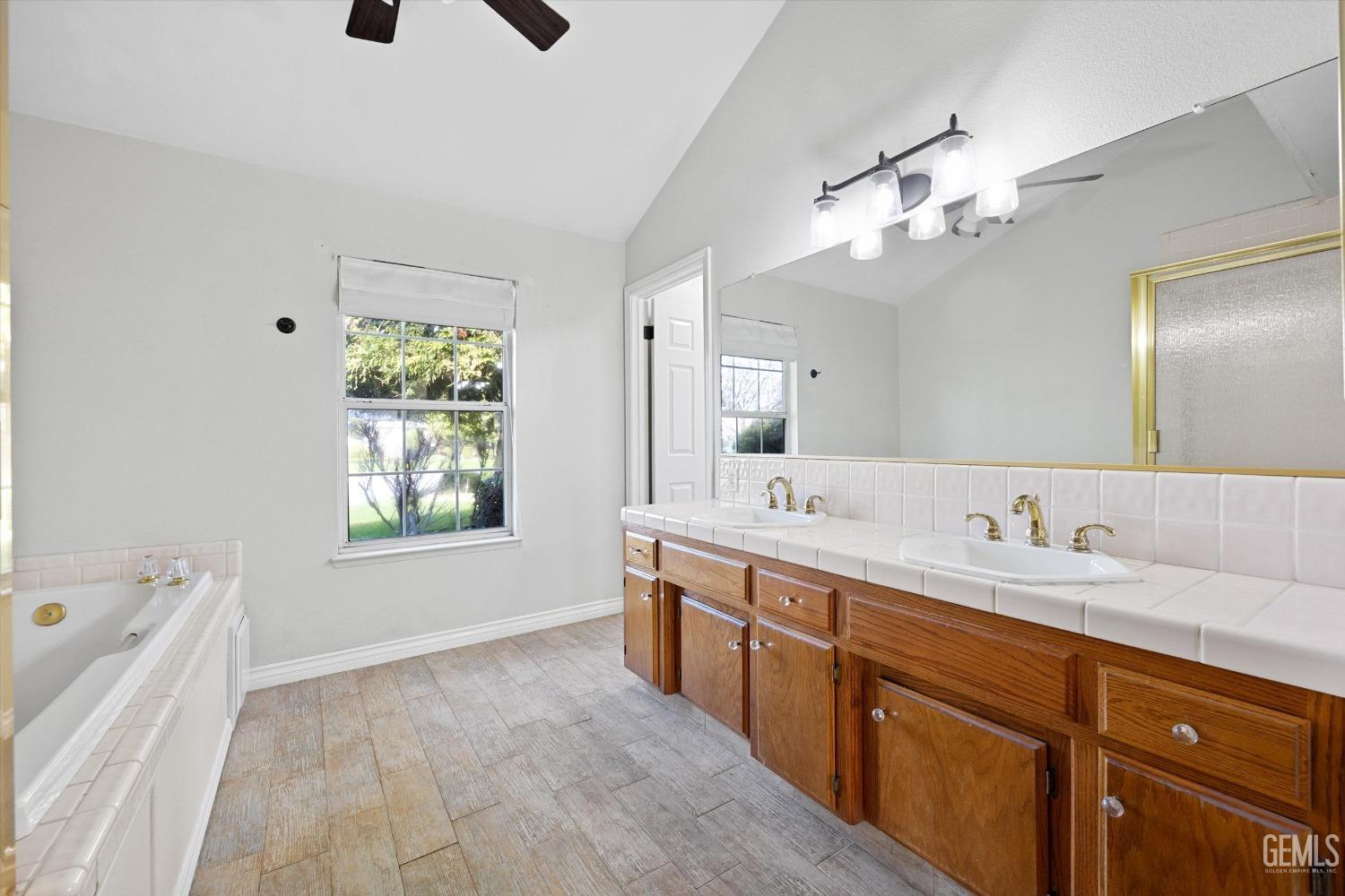 Undisclosed Address Bakersfield, CA 93308 - Photo 27 of 48 a spacious bathroom with a granite countertop sink a large mirror and a bathtub