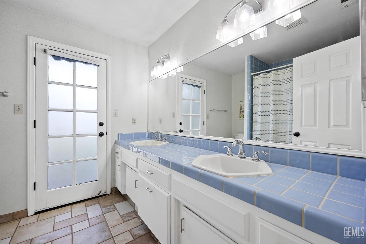 Undisclosed Address Bakersfield, CA 93308 - Photo 30 of 48 a spacious bathroom with a double vanity sink a mirror and a bathtub