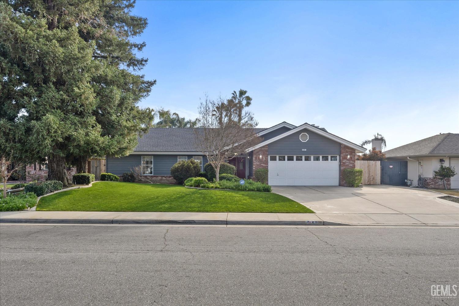 Undisclosed Address Bakersfield, CA 93308 - Photo 3 of 48 a front view of a house with a yard and garage