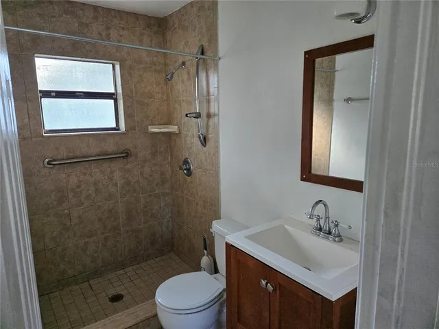 a bathroom with a sink toilet a mirror and shower
