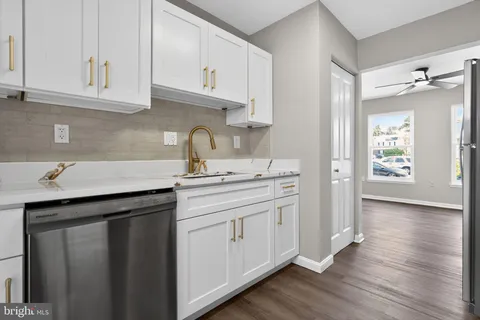 a kitchen with a sink cabinets and wooden floor