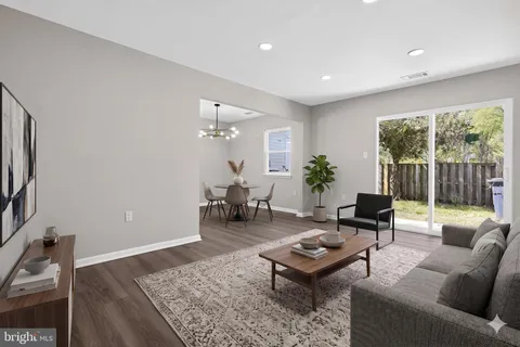 a living room with furniture a rug potted plant and a large window