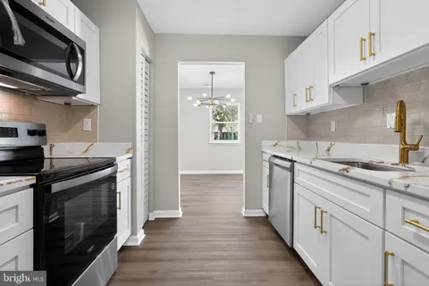 a kitchen with stainless steel appliances a stove a sink and a microwave