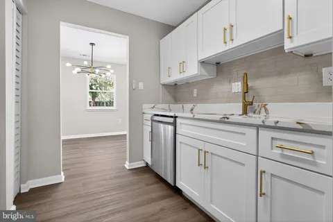 a kitchen with white cabinets and appliances