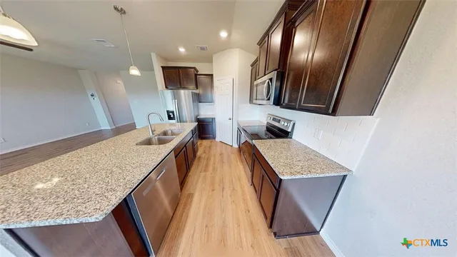 a view of kitchen island with granite countertop sink