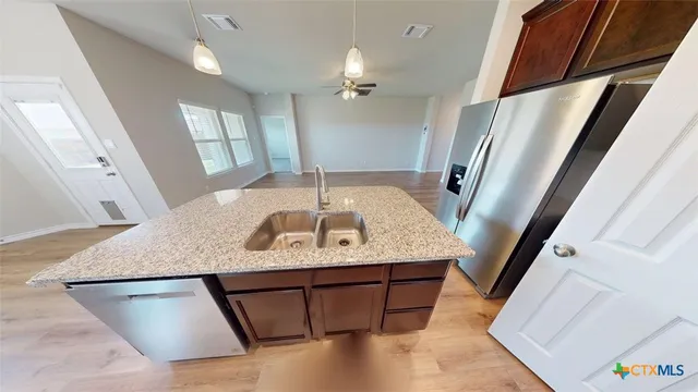 a kitchen with a stove a microwave a sink and a window