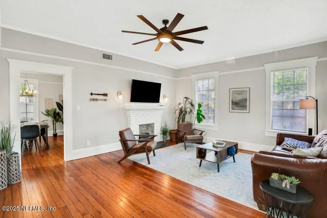 a living room with furniture and a flat screen tv with wooden floor