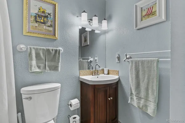 a bathroom with a sink a toilet and mirror