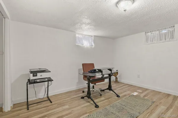 a view of a workspace with furniture and wooden floor