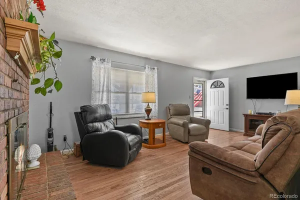 a living room with furniture a flat screen tv and a fireplace