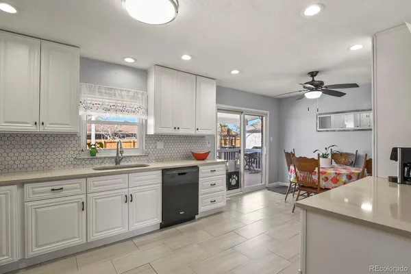 a kitchen with white cabinets and sink