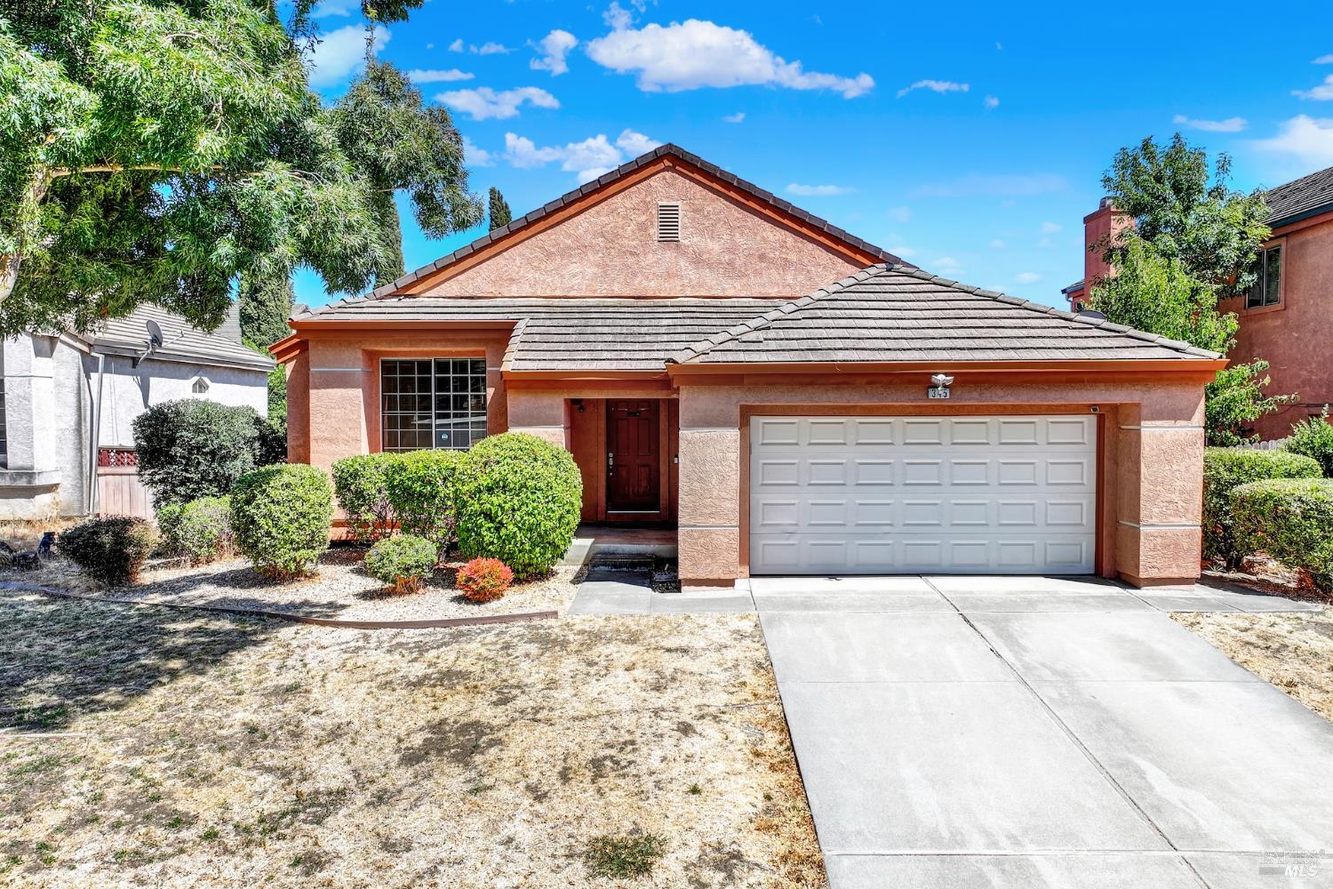a front view of a house with a yard and potted plants