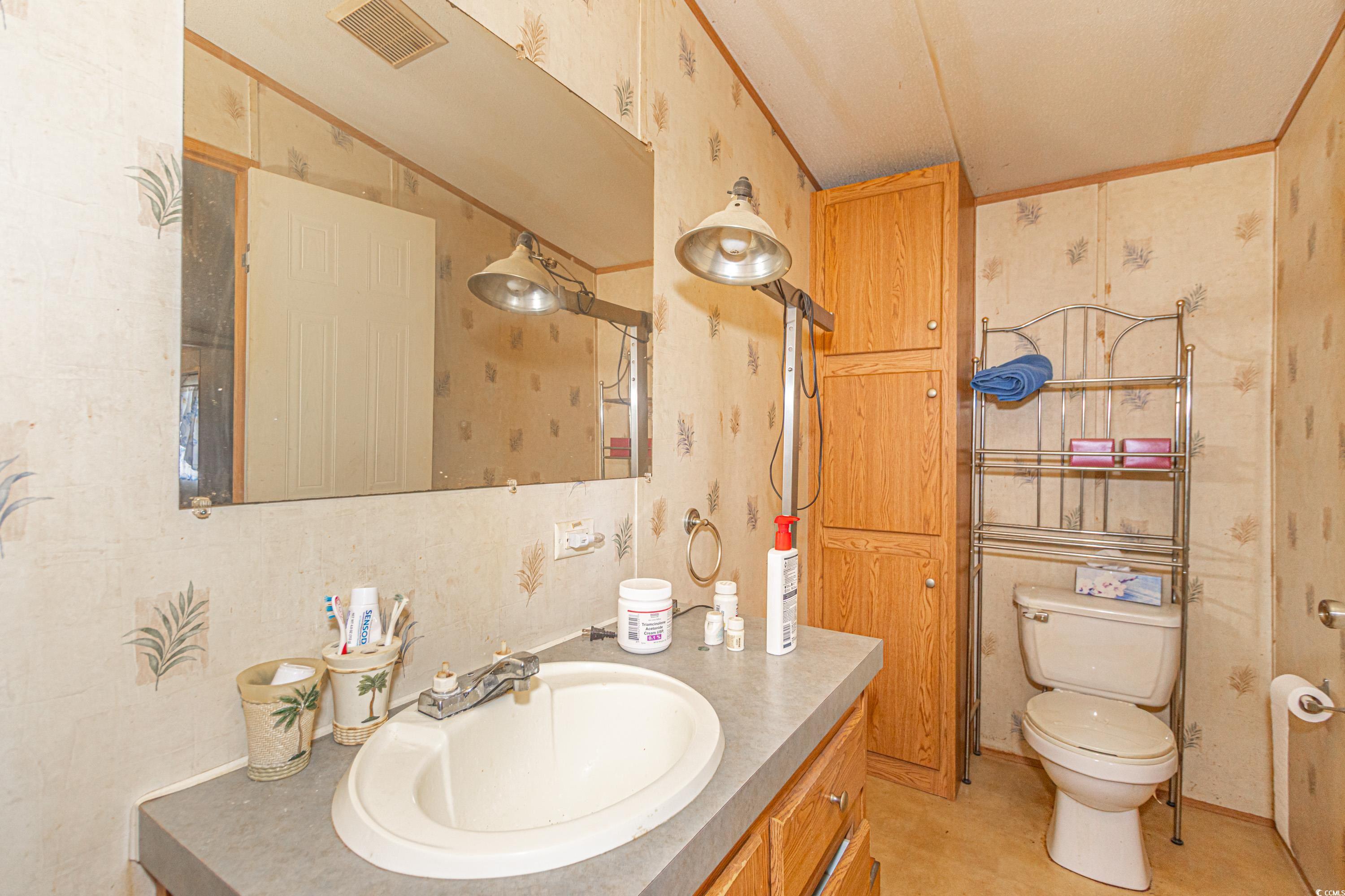 98 Offshore Drive Murrells Inlet, SC 29576 - Photo 15 of 27 Bathroom with wallpapered walls, vanity, and toile