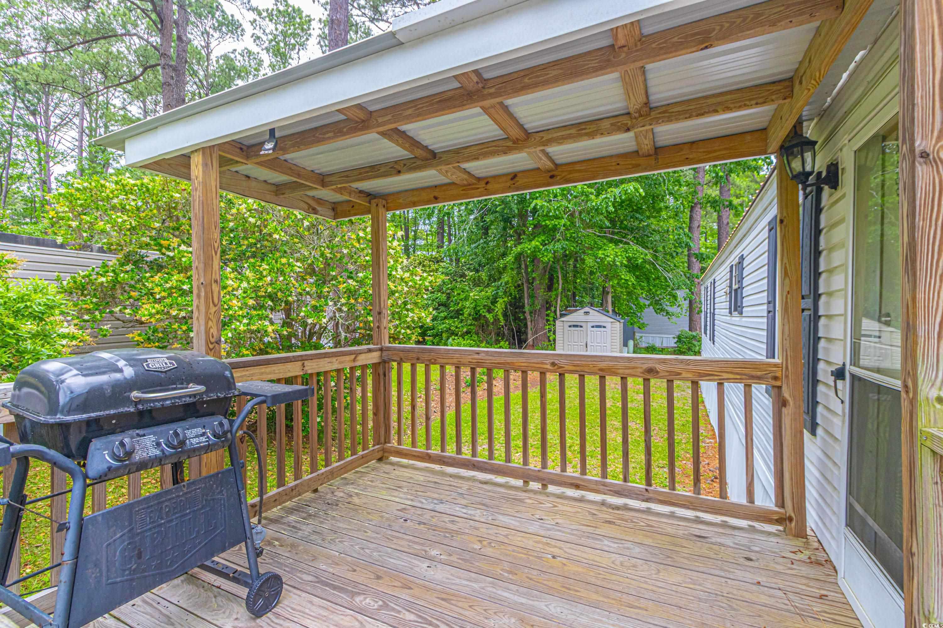 98 Offshore Drive Murrells Inlet, SC 29576 - Photo 21 of 27 Deck with a grill, a shed, and an outbuilding