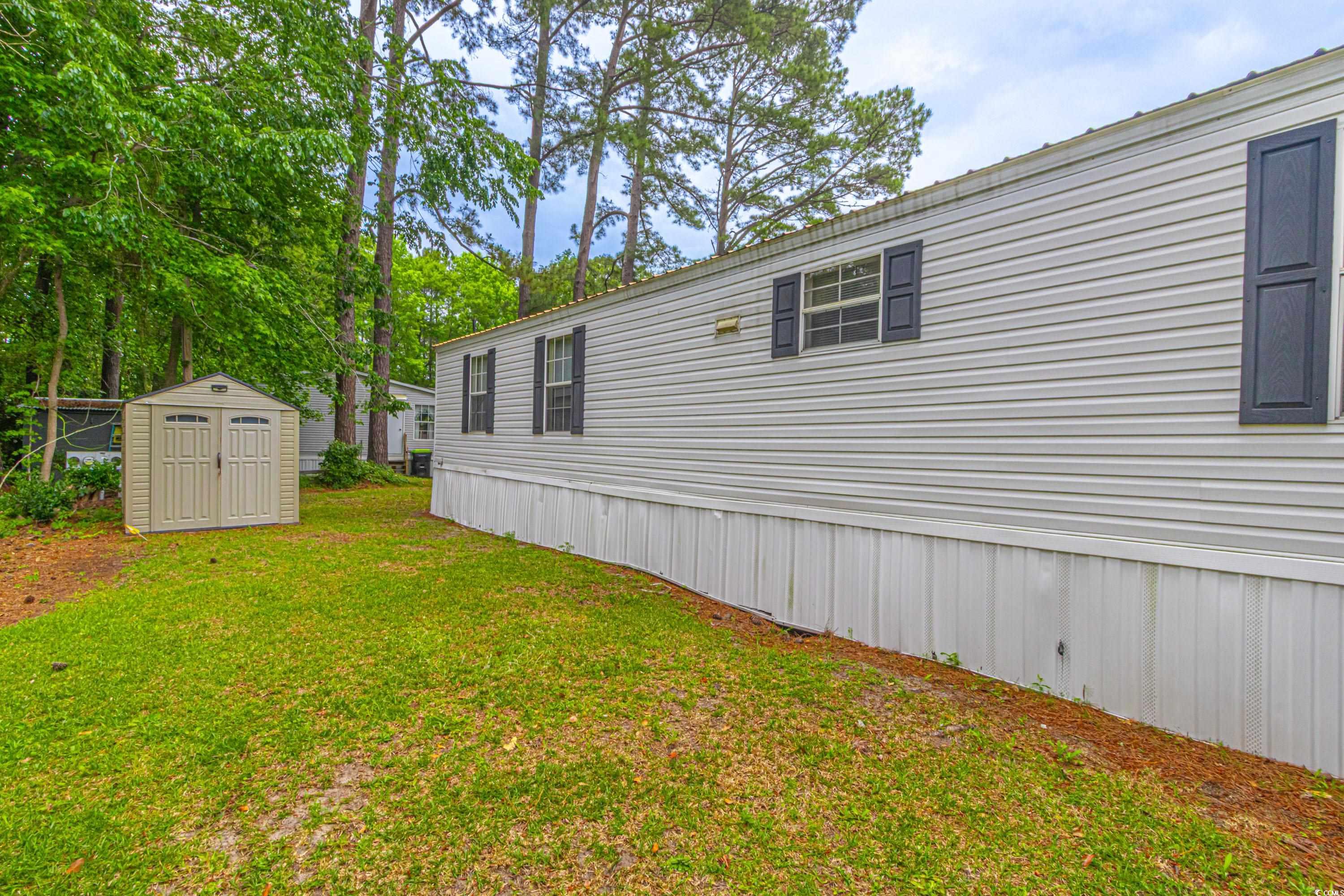 98 Offshore Drive Murrells Inlet, SC 29576 - Photo 23 of 27 View of side of home featuring a shed, a yard, and