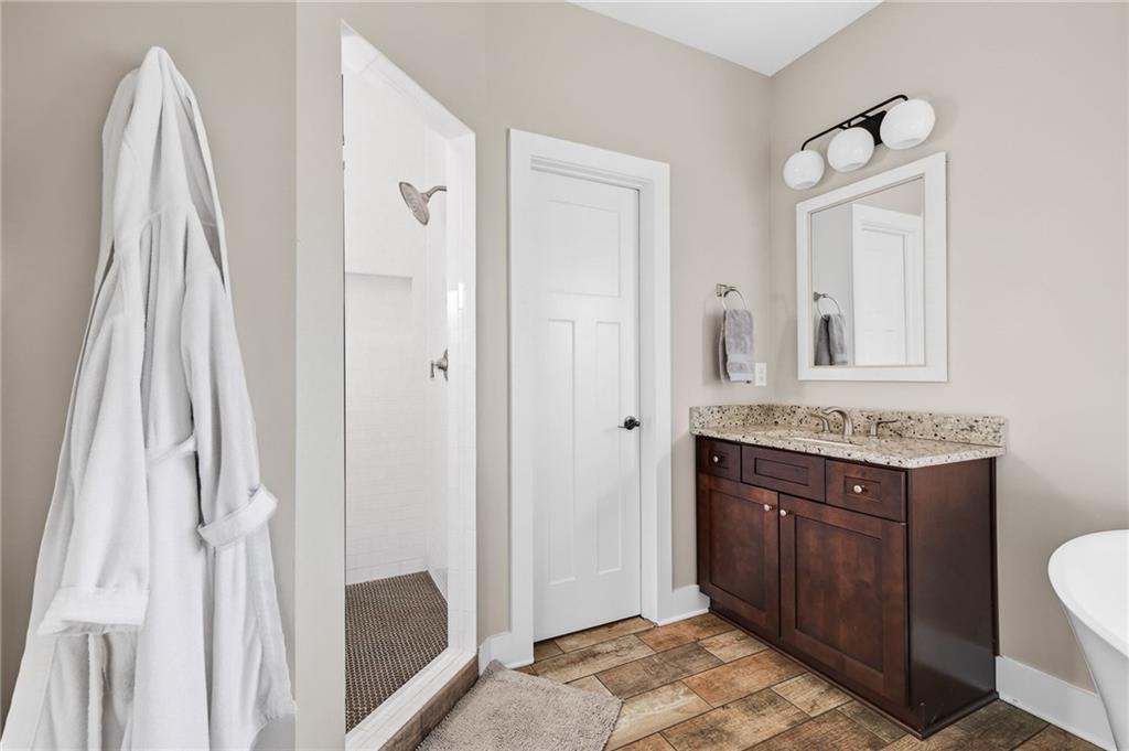 209 Ridgeland Avenue Decatur, GA 30030 - Photo 15 of 23 a bathroom with a granite countertop sink two mirror and a shower