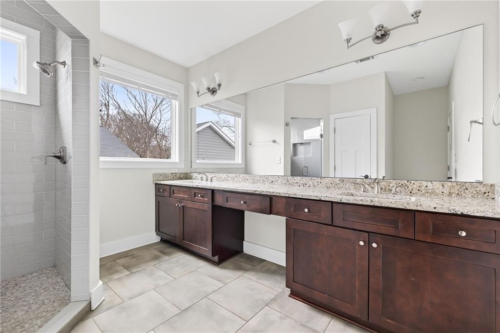 209 Ridgeland Avenue Decatur, GA 30030 - Photo 18 of 23 a bathroom with a granite countertop sink a mirror and a bathtub