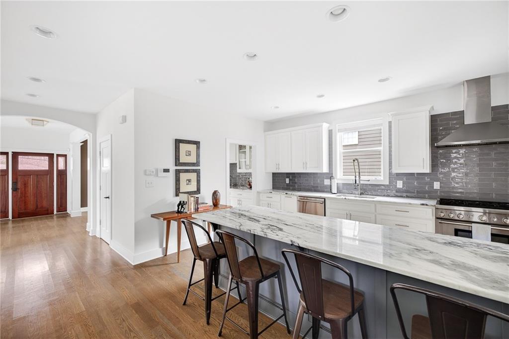 209 Ridgeland Avenue Decatur, GA 30030 - Photo 4 of 23 a kitchen with kitchen island granite countertop a table chairs sink and cabinets