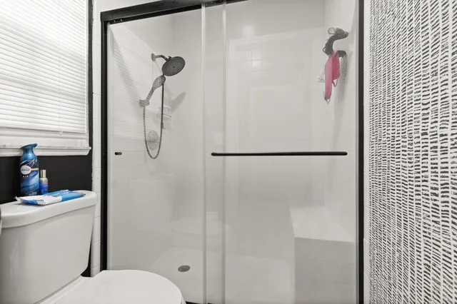 a bathroom with a shower toilet and sink