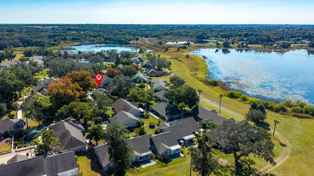 an aerial view of city and lake with trees