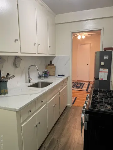 a kitchen with sink a stove and cabinets
