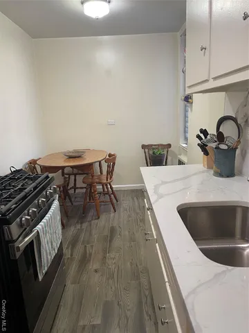 a kitchen with a sink and wooden floor